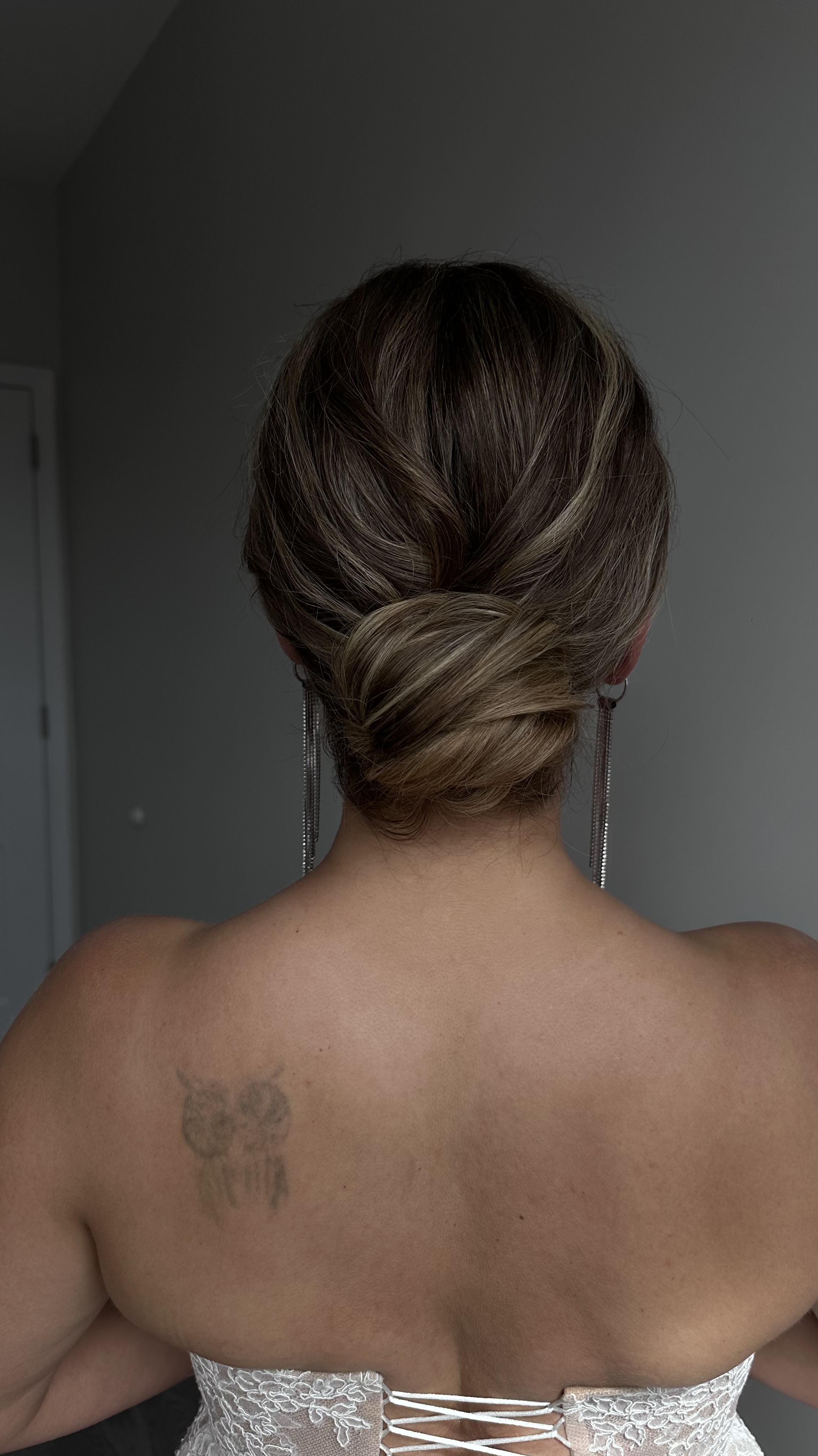 Back view of elegant low chignon; smooth finish and subtle highlights.