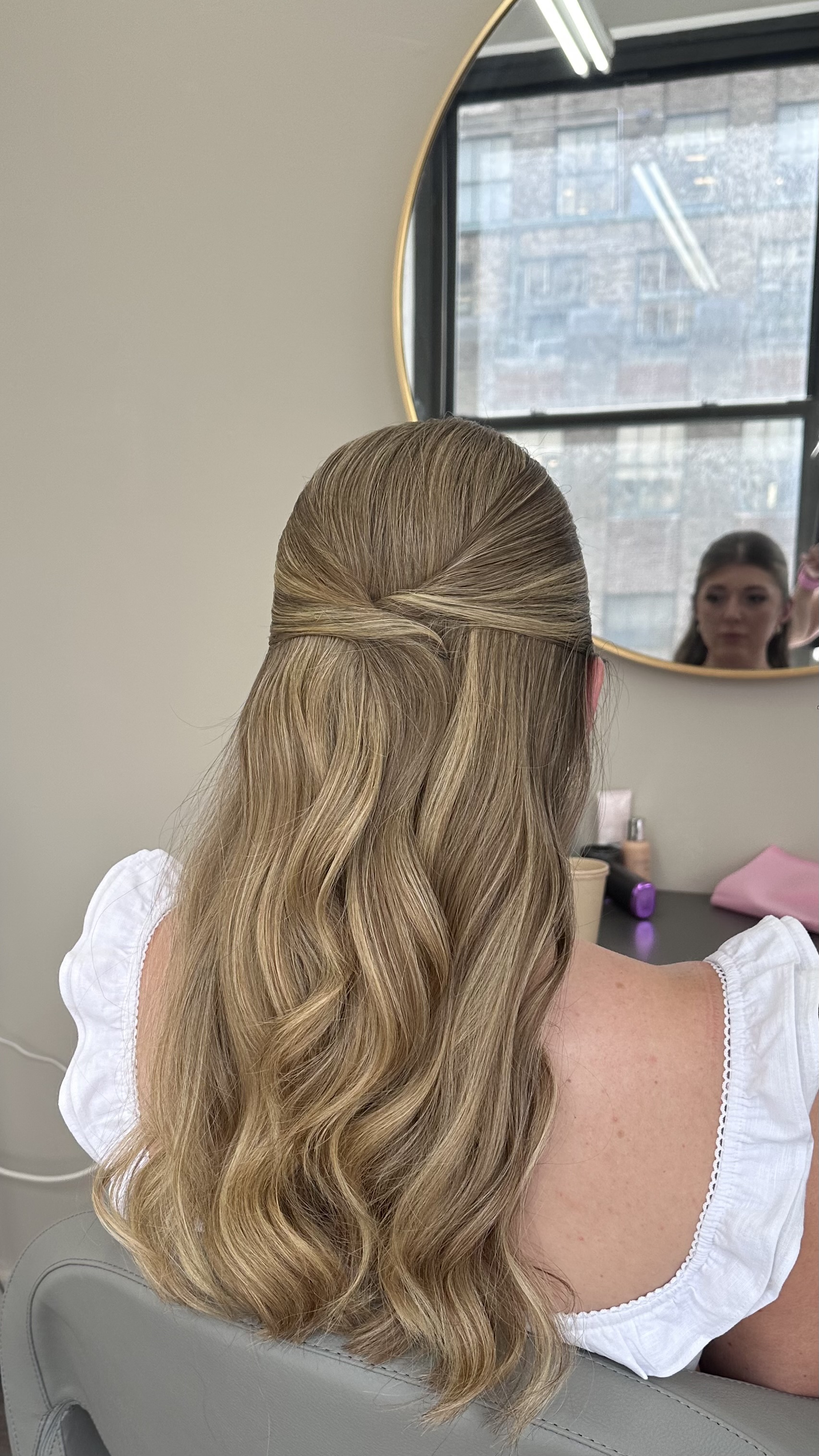 Half-up, half-down style with loose waves; twist at the crown.