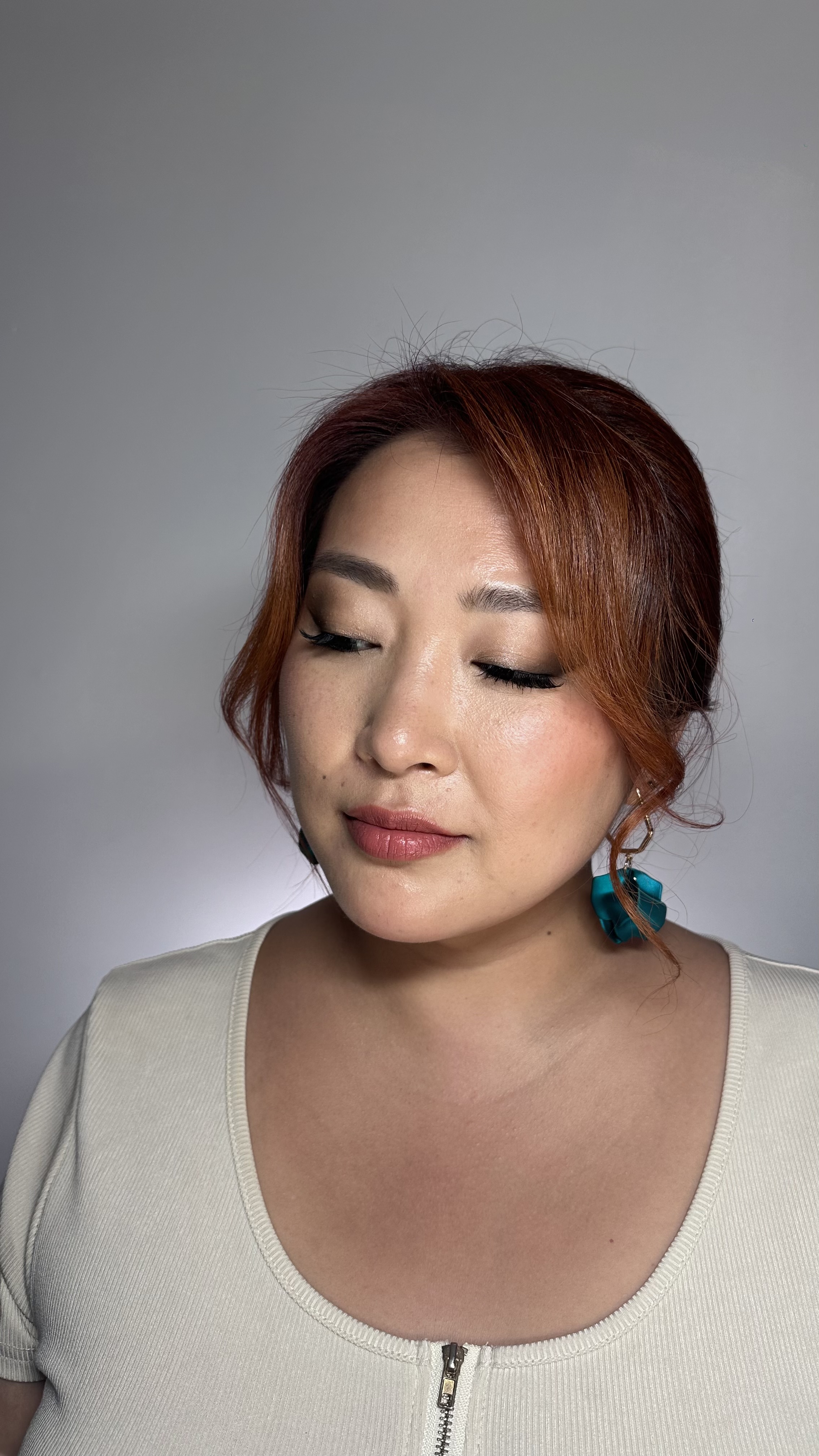 Soft bridal glam; neutral eyes with wing, full lashes, rosy lip; low updo.