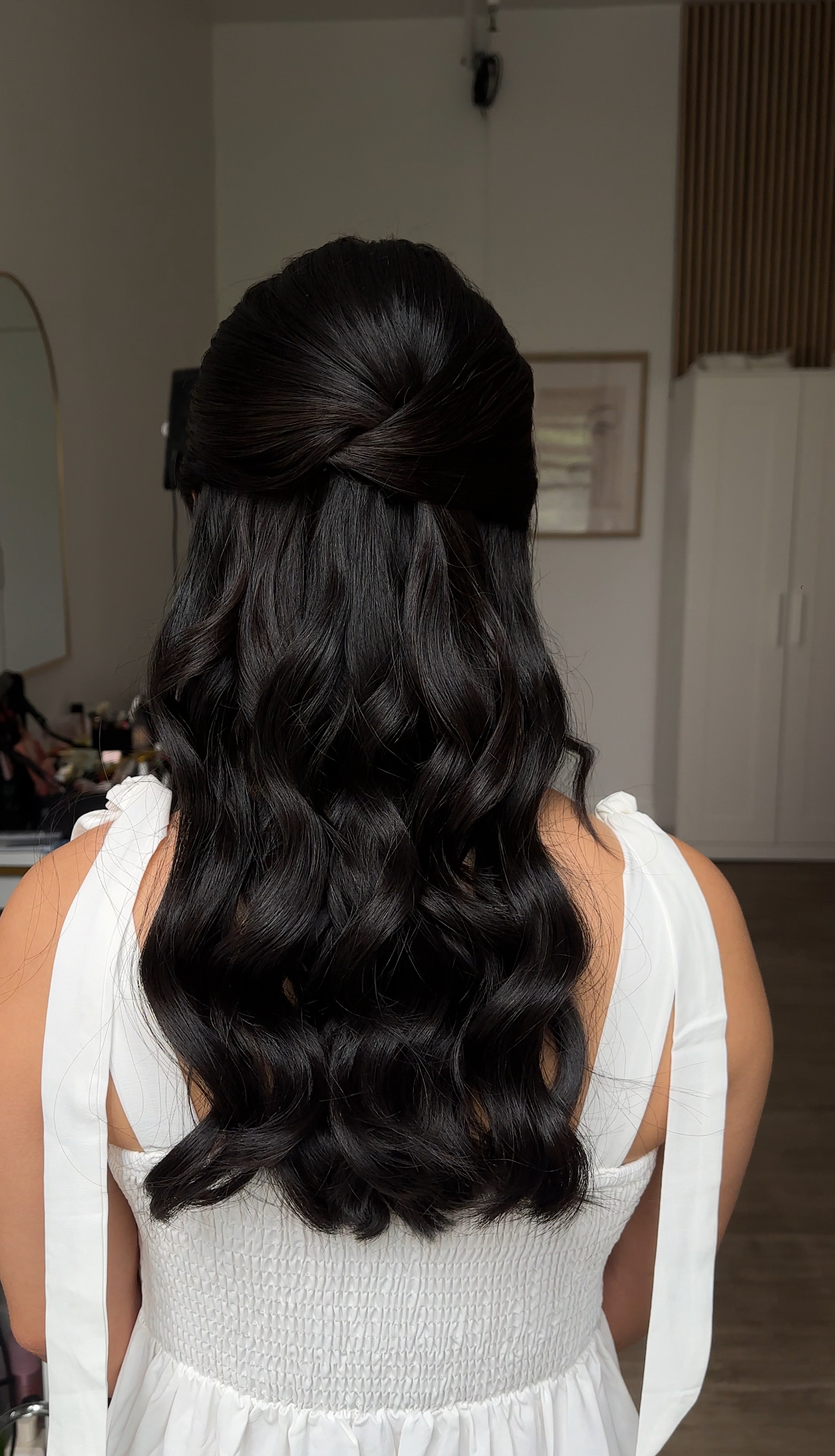 Half-up twist at the back with large waves — back view.